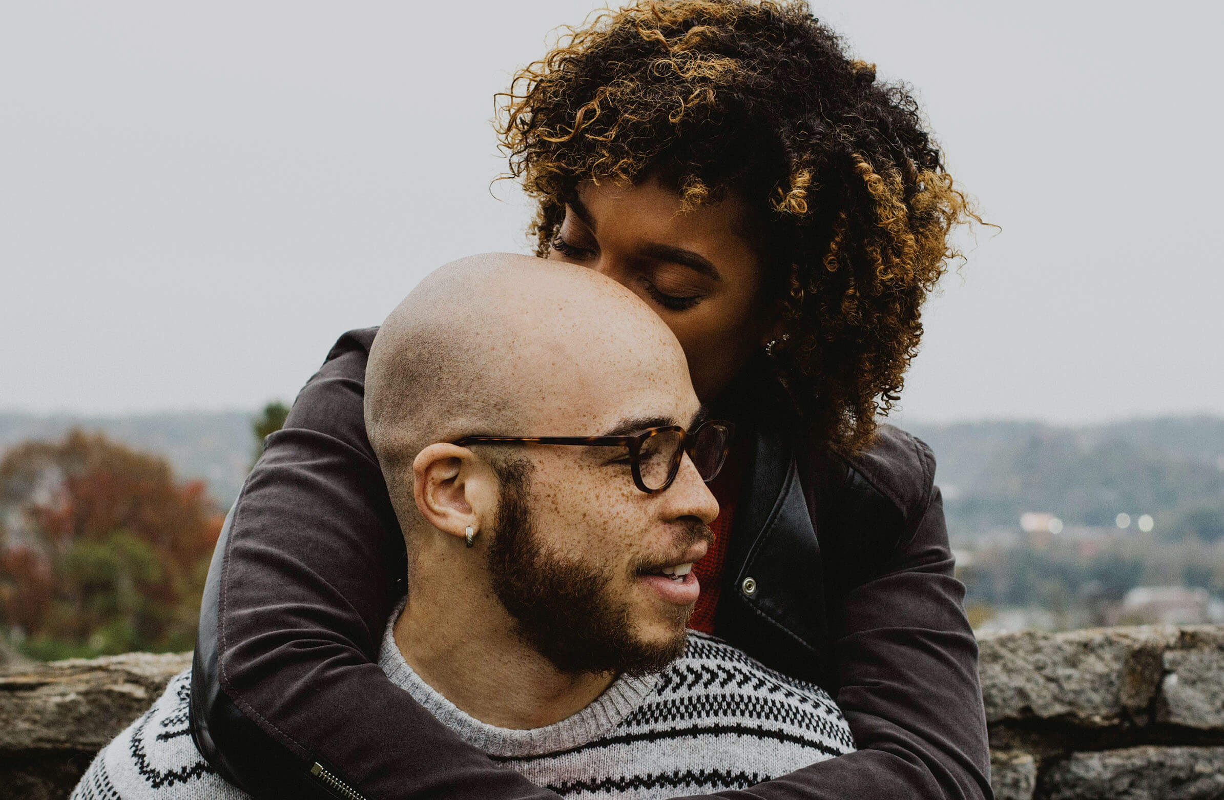 A woman lovingly embracing her partner outdoors