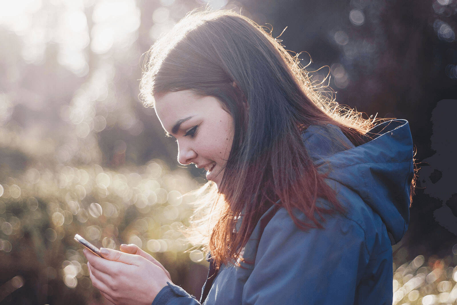 Girl outdoors looking at mobile phone