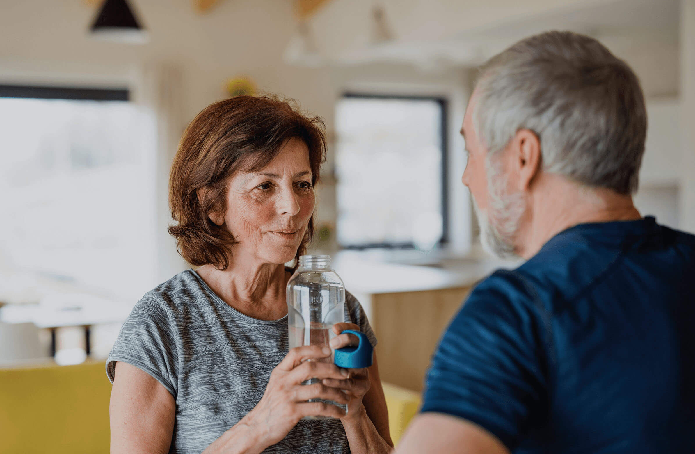 An older couple engrossed in conversation in their house